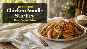 15-Minute Chicken Noodle Stir Fry served on a white plate with glossy chicken, noodles, red bell peppers, broccoli, and green beans, garnished with sesame seeds and green onions on a marble slab in a bright kitchen with text overlay.