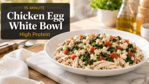 15-Minute Chicken Egg White Bowl served in a white bowl with shredded chicken, egg whites, spinach, tomatoes, and quinoa on a marble slab in a bright kitchen with natural light.