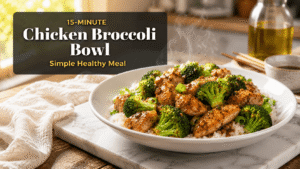 Healthy chicken broccoli bowl with juicy chicken, crisp broccoli, and rice served on a white plate in a bright kitchen setting with natural light and rustic food styling.